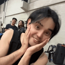 a man with his hands on his face is smiling and looking at the camera