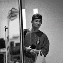 a black and white photo of a young man wearing a hat