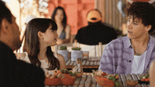 a group of people are sitting at a table talking