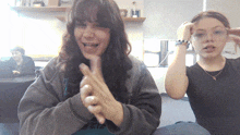 two girls sitting next to each other with one wearing a black shirt