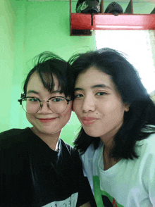 two girls are posing for a picture and one has a shirt that says ecl