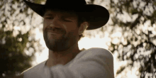 a man wearing a cowboy hat and a white shirt