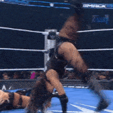 two women are wrestling in a ring with a sign that says ' smackdown ' on it