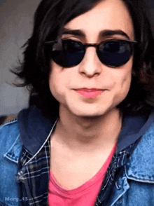 a young man wearing sunglasses and a plaid shirt