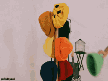 a bunch of hats are hanging on a rack with gifsdayrol written on the bottom right