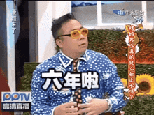 a man in a blue polka dot shirt and tie is on a tv show in chinese