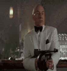 a man in a tuxedo is pointing a gun