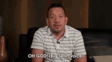 a man in a striped shirt is sitting on a couch and says oh god big sean voice