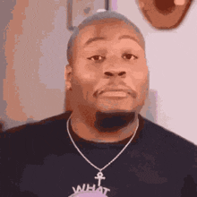 a man wearing a necklace with an ankh pendant on it