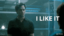 a man in a black shirt is standing in front of a sign that says i like it