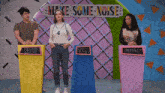 a group of people standing in front of a sign that says make some noise