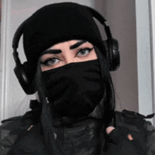 a woman wearing headphones and a black mask covering her face
