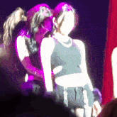 a woman in a black tank top is standing next to another woman