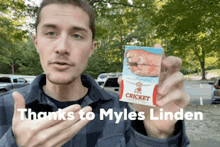 a man is holding a package of cricket cigarettes