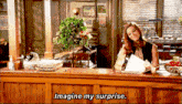 a woman sits at a counter with the words imagine my surprise written on it