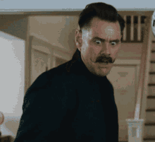 a man with a mustache is making a face
