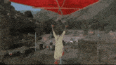 a red parachute is flying over a military camp