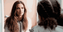 a woman in a white shirt is talking to another woman and says " yeah "