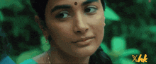 a close up of a woman 's face with xhk written in yellow