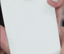 a person is holding a piece of white paper