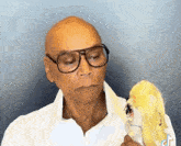 a man wearing glasses and a white shirt is holding a stuffed animal .