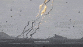 a giant jellyfish is floating in the air over a rocky beach .
