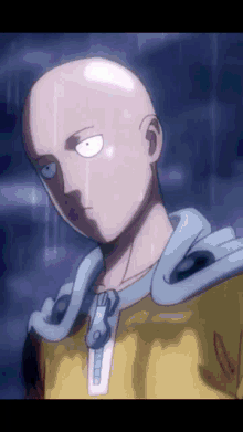 a close up of a bald man 's face with a yellow jacket on