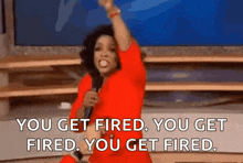 a woman in a red dress is holding a microphone and saying you get fired .