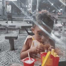 a little girl is eating french fries from a mcdonald 's bag