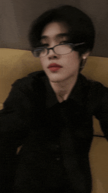 a man wearing glasses and a black shirt takes a selfie