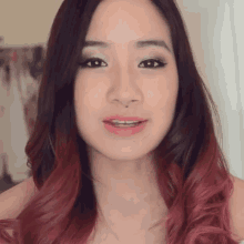 a close up of a woman 's face with long red hair .