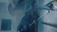 a man in a blue shirt is playing a violin