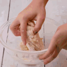 a person is holding a piece of dough in a bowl