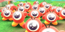 a bunch of red cartoon characters with big eyes are standing next to each other on the grass .