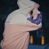 a person wearing a pink white and purple jacket with the word atari on the sleeves