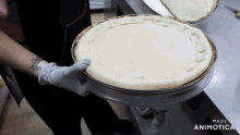 a person is holding a pizza in front of a made in animatica logo