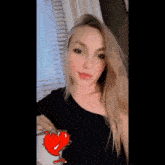 a woman wearing a black shirt with a heart on it