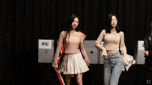 two girls are dancing in front of a sign that says ' 코토 ' on it
