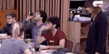 a group of people are sitting at a table drinking and talking .