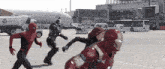 a man in a spiderman costume is standing next to a man in a iron man suit