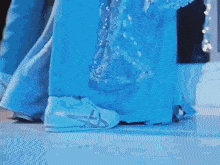 a person wearing a blue dress and white shoes is dancing