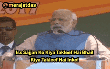 a man speaking into a microphone with the words iss sajjan ko kiya takleef hai bhai kiya takleef hai inko