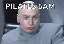a bald man with the words pilates 6am written above him