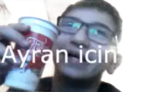 a man with glasses is holding a cup with ayran icin written on it