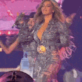 a woman in a very revealing jumpsuit is singing into a microphone on a stage .