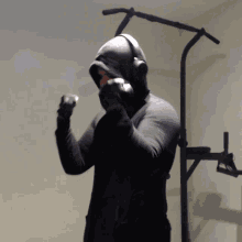 a man wearing a hooded jacket is holding a pair of dumbbells