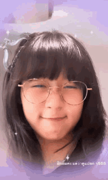a girl wearing glasses is smiling with a purple background in the background