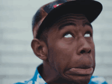 a close up of a man wearing a hat and making a funny face