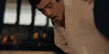 a man is laying on a table with his legs crossed and his head down .