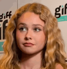 a close up of a woman 's face with long blonde hair